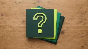 Fragekarten mit Fragezeichen auf einem Tisch neben einem geschlossenen Notizbuch